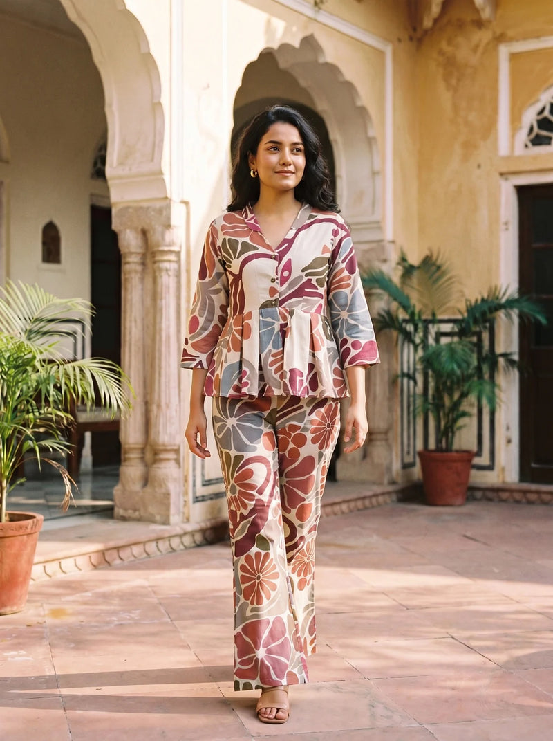 woman in maroon floral peplum co ord set by a carved door