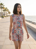 model in red and blue printed co-ord set walking seaside golden hour