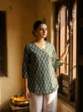 woman in bottle green botanical kurti at a heritage haveli