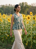 woman in green botanical peplum co ord set by the pool at night