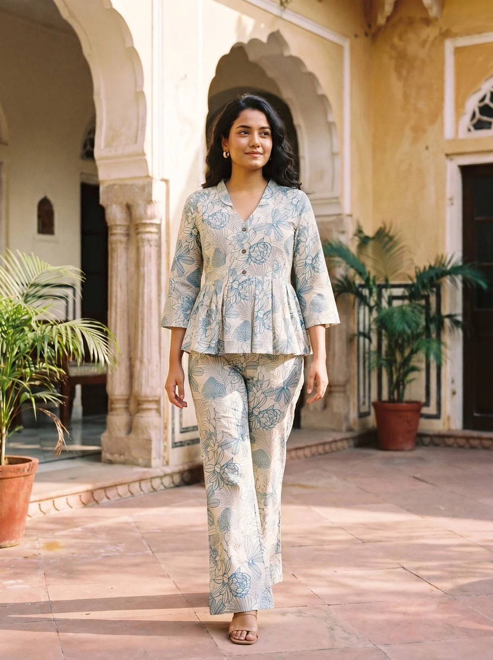 woman in rama floral co ord set by a carved door